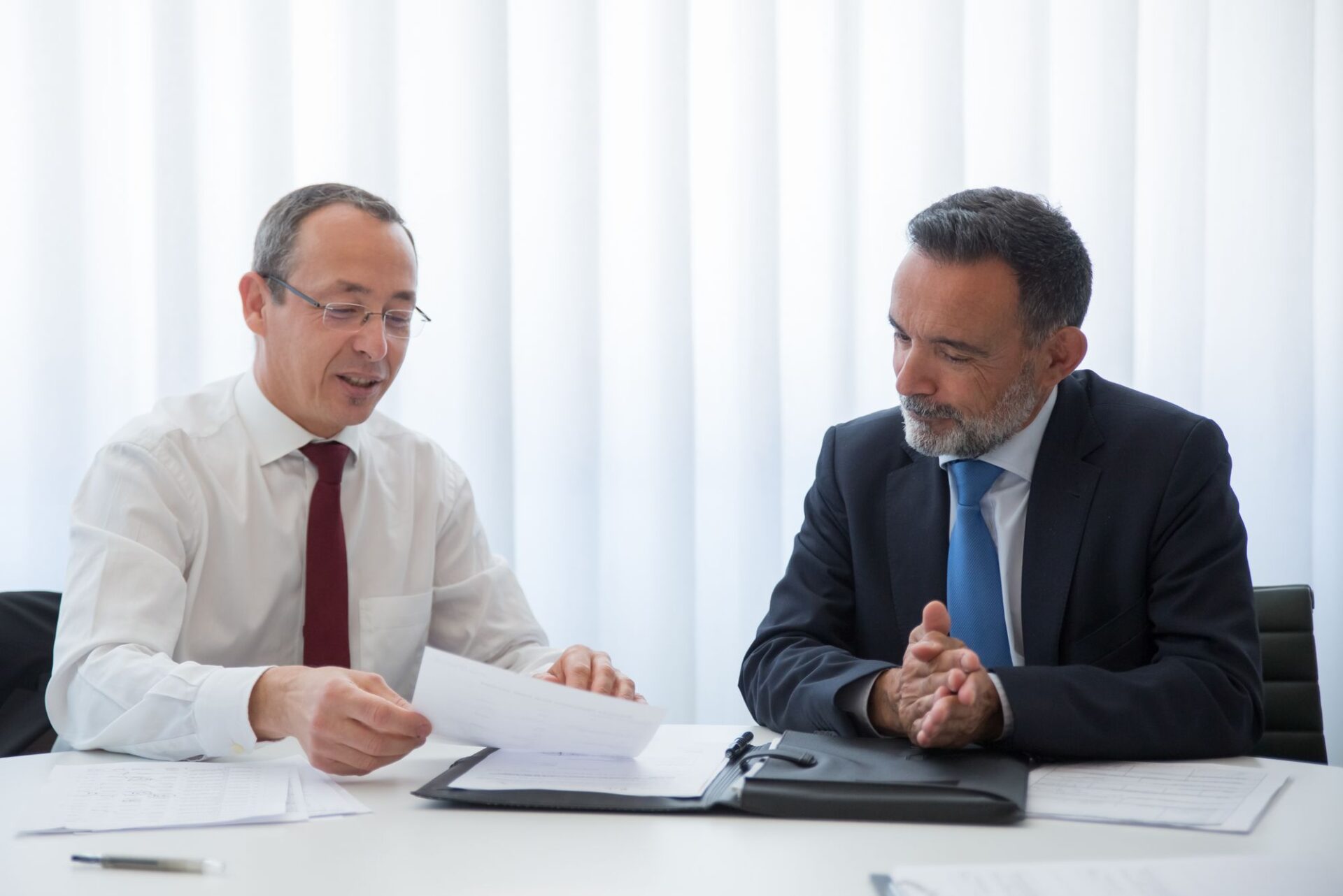 Twee mannen bespreken documenten aan tafel